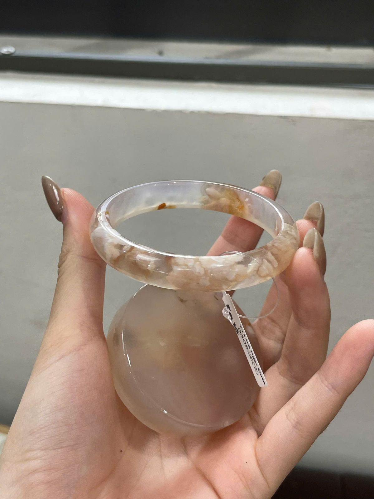 Vòng Mã Não Hoa Anh Đào Ni 53.1 với cụm trắng đục, nét nâu uốn ở cung trước và chấm nâu phía xa